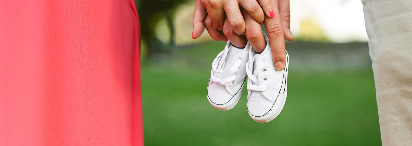 Nahaufnahme: Pärchen hält Kinderschuhe in der Hand