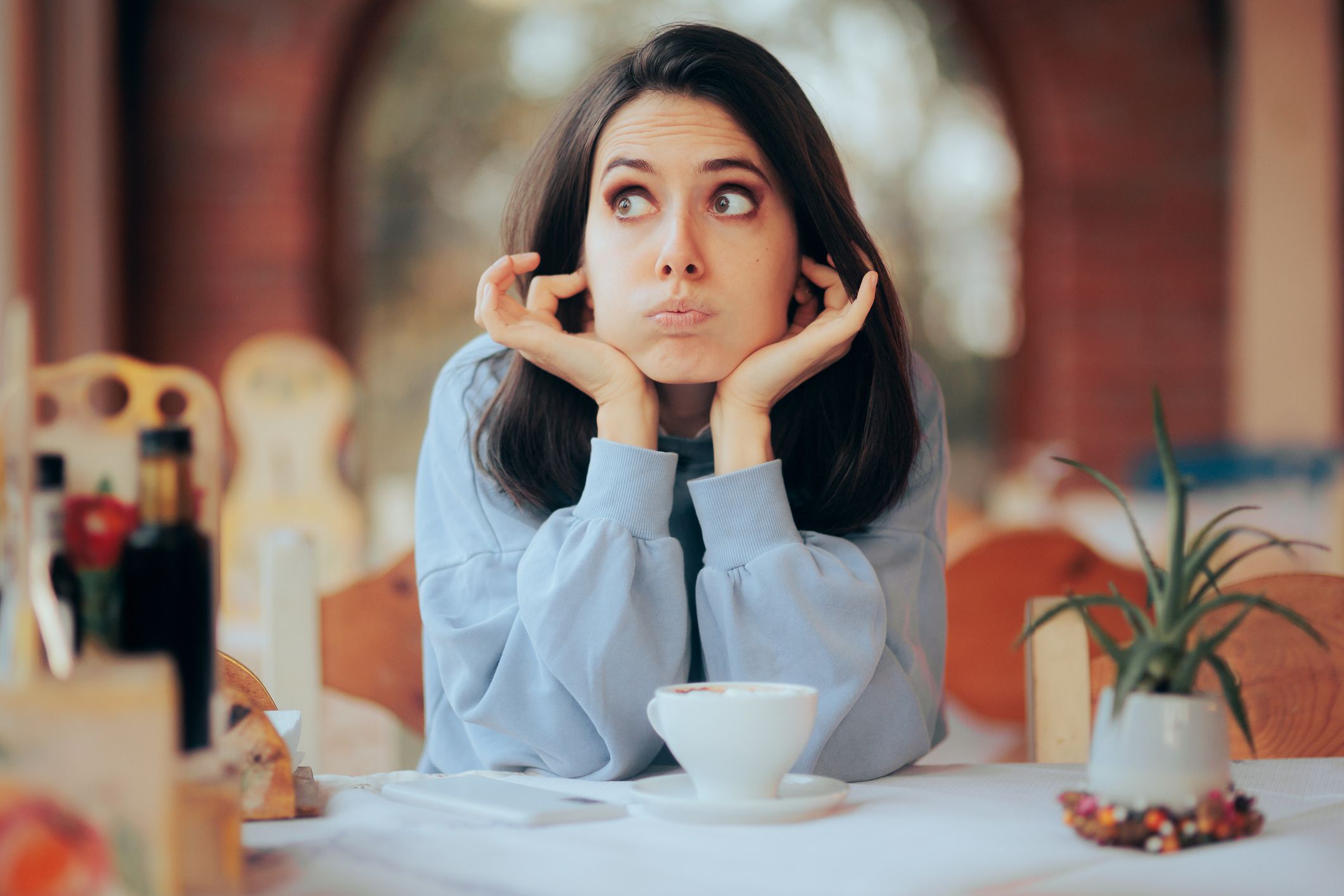 Nachdenkliche Frau ohne Kinder bei einem Kaffee