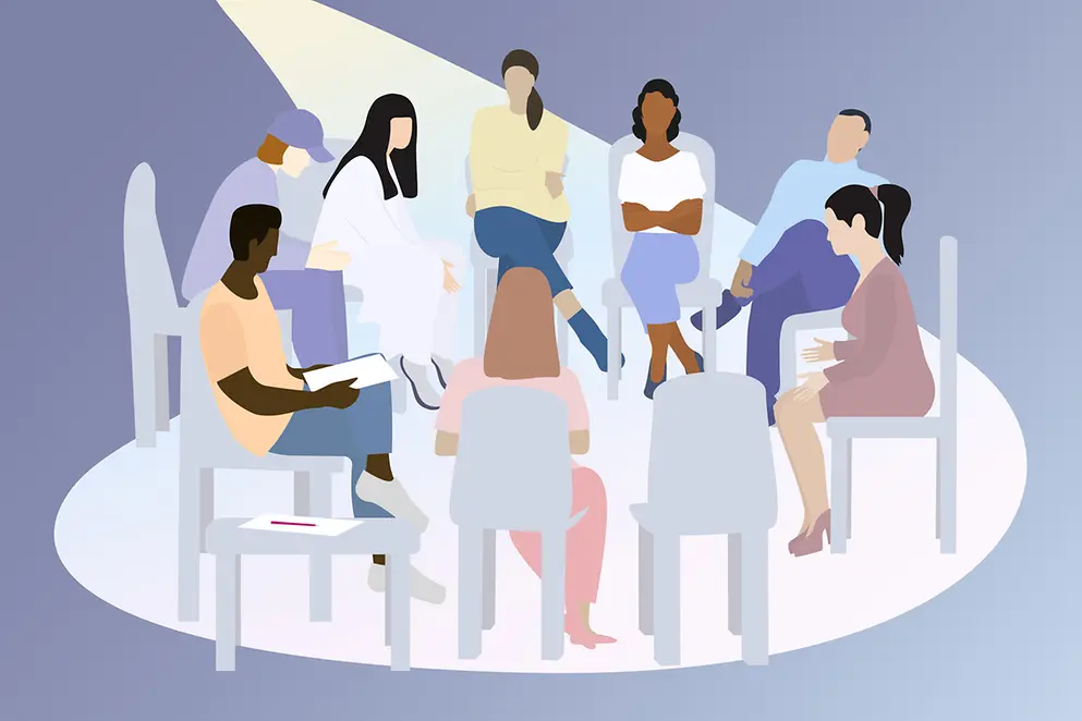 Eine Menschengruppe sitzt im Stuhlkreis